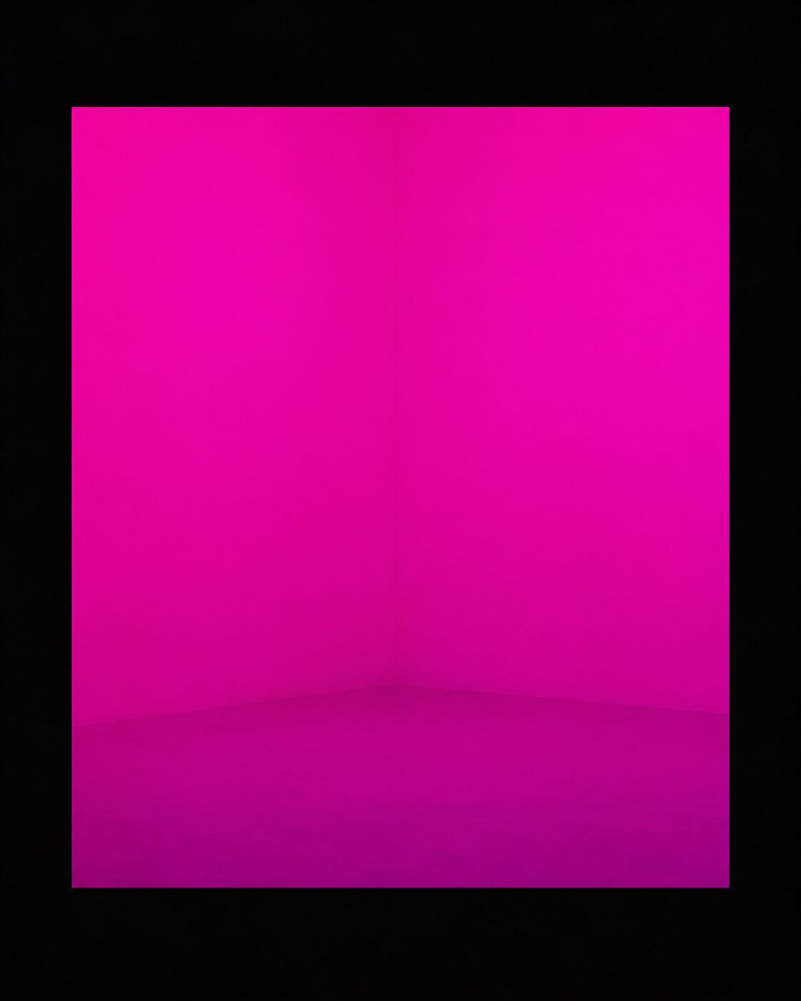 A rectangular field of saturated magenta light filling the centre of the frame, with a faint tonal step where wall meets floor.