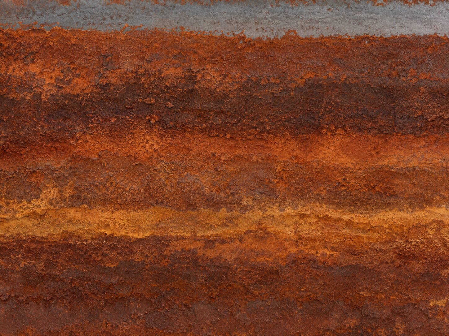 A sheet of weathered corten steel filling the frame, its surface banded horizontally in orange and umber rust.